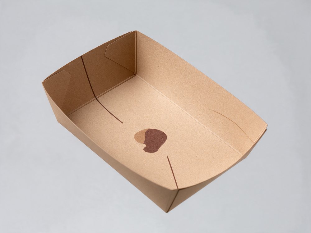 A printed kraft food tray held against a plain background