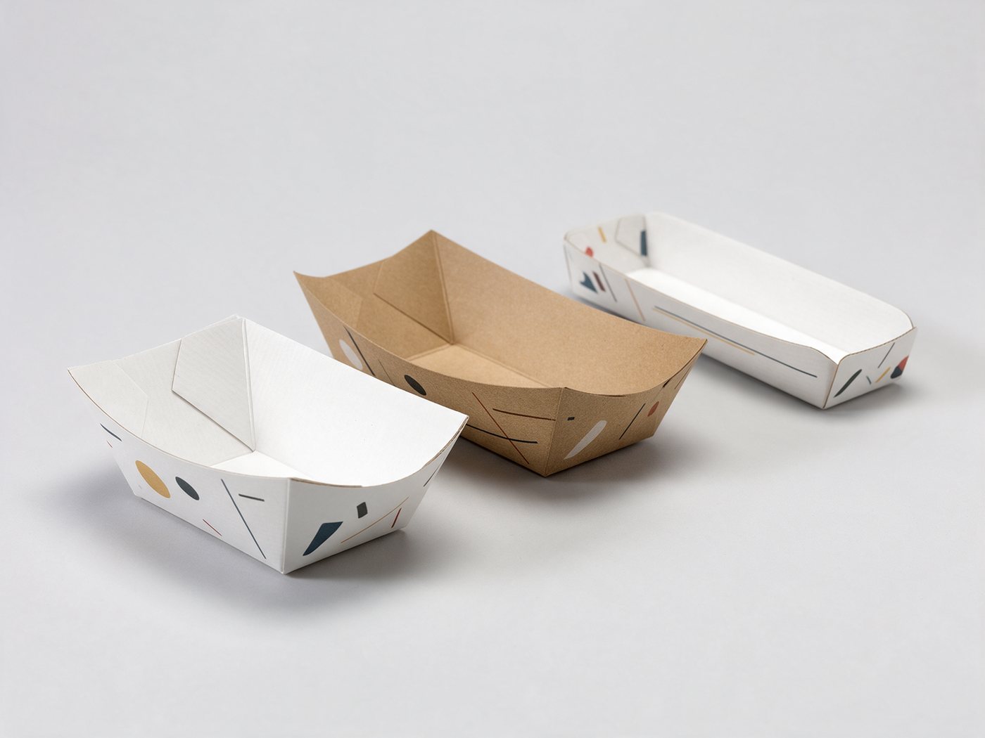 Custom printed paper food trays in white and kraft on a studio surface